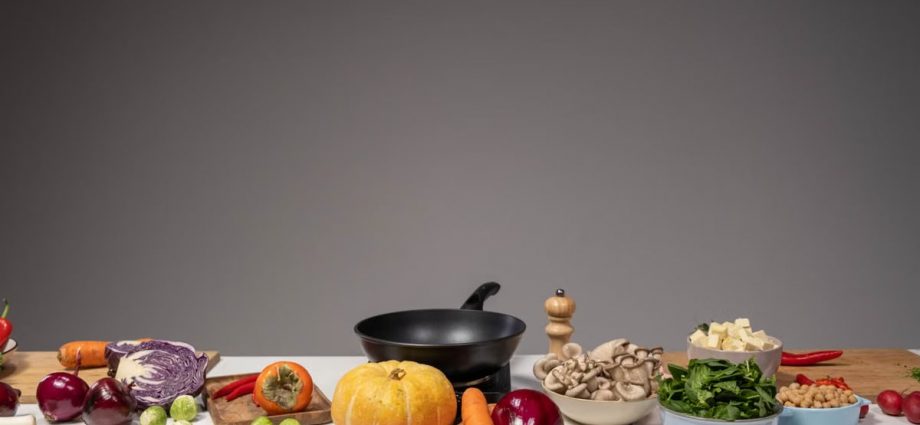 Studio composition of fresh vegetables and a frying pan, ideal for healthy cooking and recipe preparation.